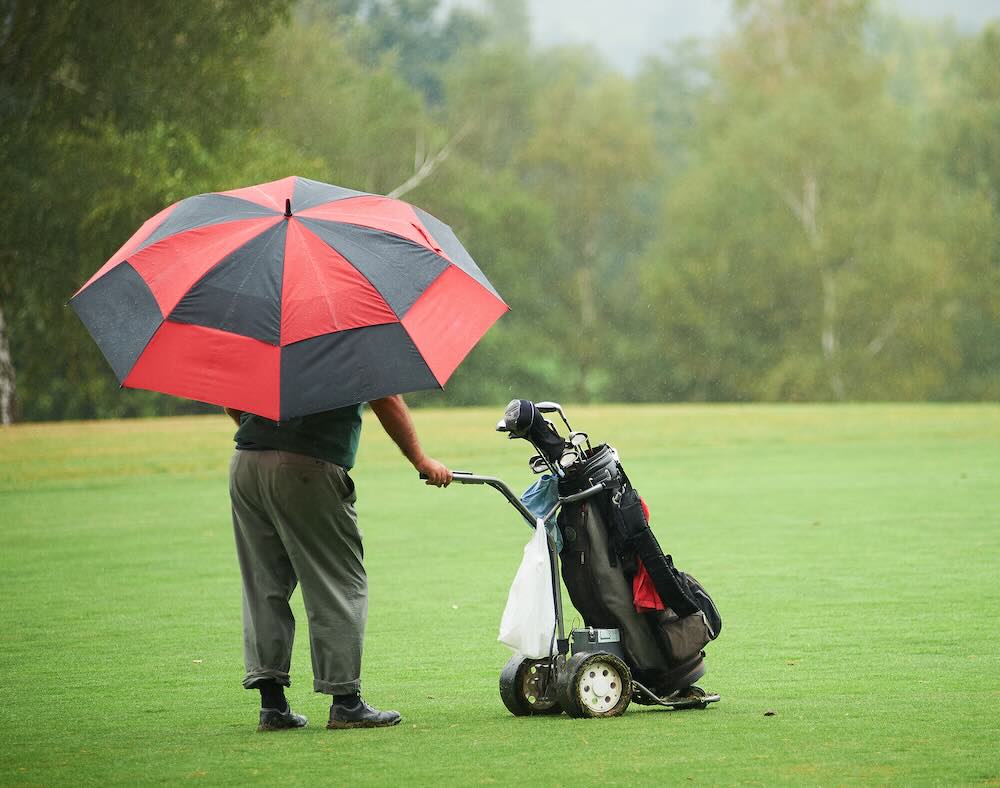 Golfer playing while it rains 